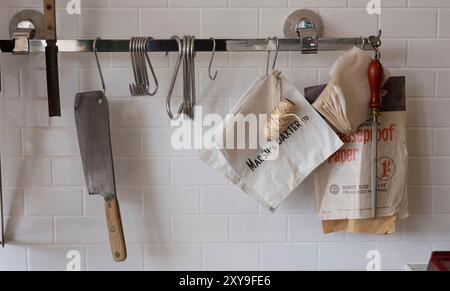 Dudley, West midlands regno unito 15 novembre 2021 vecchi utensili da cucina appesi su un muro di cucina piastrellato di bianco Foto Stock