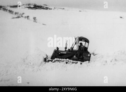 Un Bulldozer/Crawler cingolato elimina la neve da una strada di campagna vicino a Dodburn, Hawick durante l'inverno estremo del 1963. Scottish Borders, Regno Unito. Foto Stock