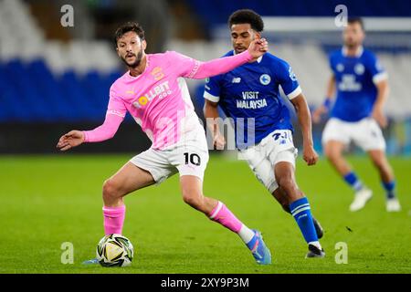 Adam Lallana di Southampton (a sinistra) e Andy Rinomhota di Cardiff lottano per il pallone durante la partita del secondo turno della Carabao Cup al Cardiff City Stadium. Data foto: Mercoledì 28 agosto 2024. Foto Stock