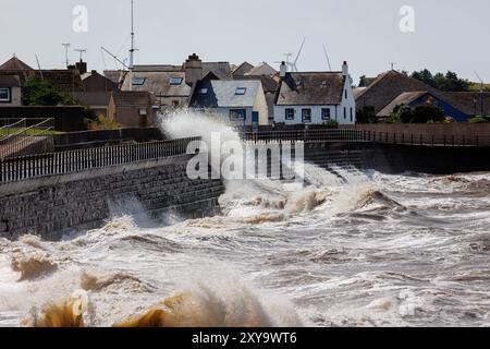 Mari tempestosi che creano enormi onde contro gli scalini all'ingresso del porto di Maryport Foto Stock