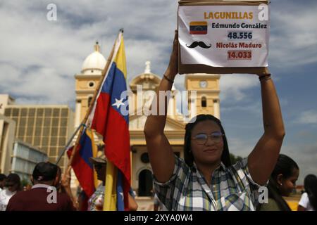 Maracaibo, Venezuela. 8 agosto 2024. Una giovane donna con in mano una scatola che simula quelli utilizzati dal CNE, chiede che i risultati del processo verbale siano pubblicati, tabella per tavola questo mercoledì, 28 agosto, presso la Basilica della Vergine di Chiquinquira nella città di Maracaibo, Venezuela. (Foto di Humberto Matheus/Sipa USA) credito: SIPA USA/Alamy Live News Foto Stock