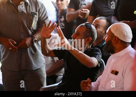 Rahat, Rahat nel sud di Israele. 28 agosto 2024. L'ostaggio, Qaid Farhan Alkadi (fronte C), parla dopo essere stato salvato da Gaza martedì, nel suo villaggio vicino a Rahat, nel sud di Israele, il 28 agosto 2024. L'esercito israeliano ha annunciato martedì che le sue forze avevano salvato un ostaggio israeliano da un tunnel sotterraneo nella Striscia di Gaza meridionale durante la lotta contro l'area. Qaid Farhan Alkadi, 52 anni, è stato trovato da solo in un tunnel, senza guardie o altri ostaggi, ha detto l'esercito in una dichiarazione. Crediti: Jamal Awad/Xinhua/Alamy Live News Foto Stock