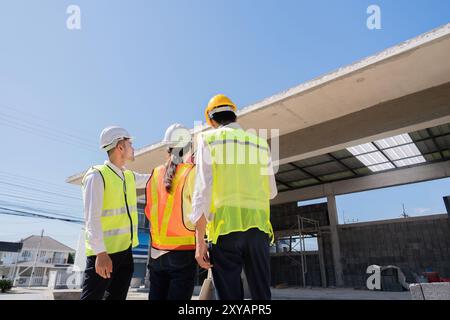 Il team di costruzione sta valutando lo stato di avanzamento dell'edificio in loco. Ispezione e pianificazione Foto Stock