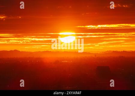 Il caldo sole mattutino di Los Angeles scoppia tra le nuvole e la nebbia sopra la San Fernando Valley. Foto Stock