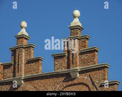 Dettaglio di una tradizionale facciata in mattoni con ornamenti decorativi sotto un cielo limpido e nuvoloso, alkmaar, paesi bassi Foto Stock