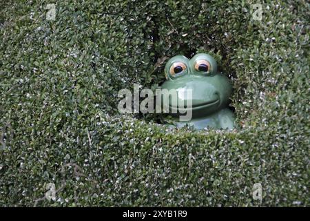 Rana in ceramica verde in una siepe Foto Stock