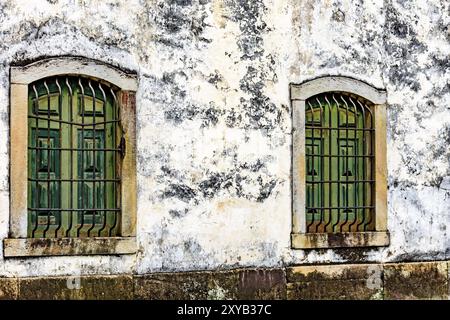 Il vecchio e di età storica chiesa in legno finestre con cornice in pietra e le griglie nella città di Ouro Preto, Minas Gerais con una cornice di pietra Foto Stock