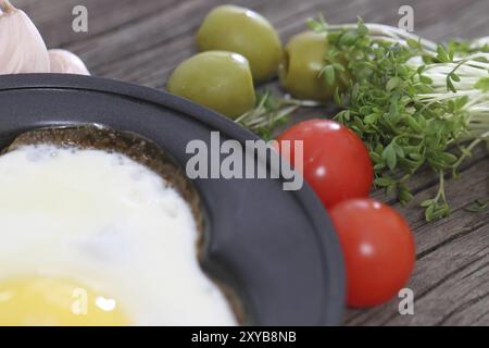 Uovo fritto nel cuore-forma sagomata con crescione, pomodoro, aglio, olive Foto Stock