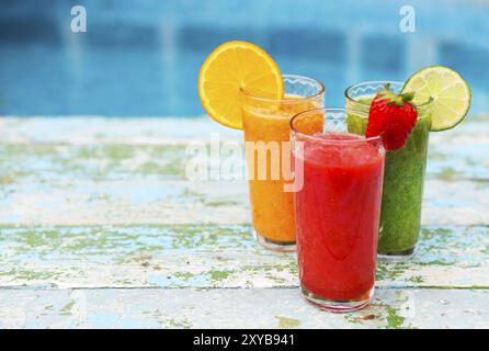 Assortimento di frutta e verdura frullati in vetro bianco su sfondo di legno. Fresco frullato di organico. Superfoods e salute o detox la dieta con alimenti Foto Stock