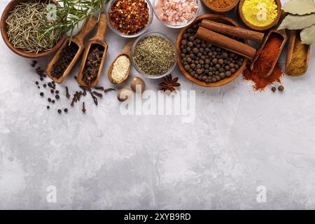 Le spezie e le erbe oltre la pietra grigia sfondo vista superiore con spazio libero per menu o ricette Foto Stock