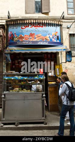 I turisti acquistano spuntini al negozio di snack al Kelany nel mercato di Khan El Khalili al Cairo, in Egitto. Foto Stock