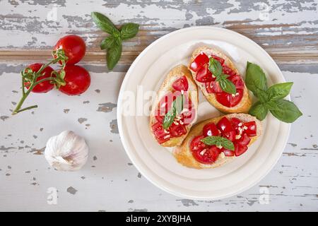 Italian bruschetta con pomodoro, basilico e aglio su una piastra visto da sopra Foto Stock