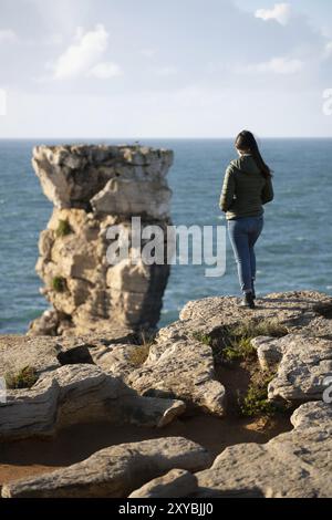 Donna nel paesaggio delle scogliere marine a Cabo Carvoeiro Cape che guarda all'isola di Berlengas, a Peniche, Portogallo, Europa Foto Stock