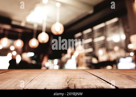 Vuoto in legno vecchio tavolo da ponte di fronte a astratto sfocato sfondo festivo in bar, caffè, pub o ristorante con punti luce e bokeh per pro Foto Stock