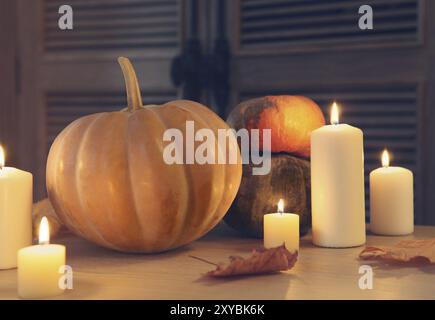 Candele accese e zucche. Luogo d'autunno. Rendimento di grazie Foto Stock