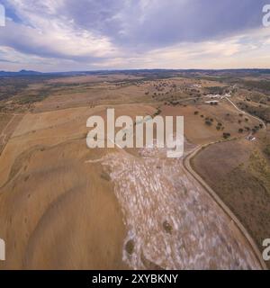 Panorama aereo di un paesaggio collinare simile a un deserto con polvere di pietre di marmo al tramonto a Terena, Portogallo, Europa Foto Stock