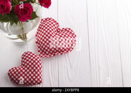 Cuori e un bouquet di rose rosa in un vaso, il giorno di San Valentino sfondo Foto Stock