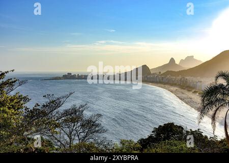 Vista dalla cima della spiaggia di Copacabana con le colline e le montagne di Rio de Janeiro sullo sfondo Foto Stock