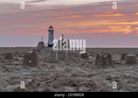 Il Sandcastles On la spiaggia, con serata nuvole e punto di Ayr il faro in background, vicino Talacre, Flintshire, Wales, Regno Unito Foto Stock