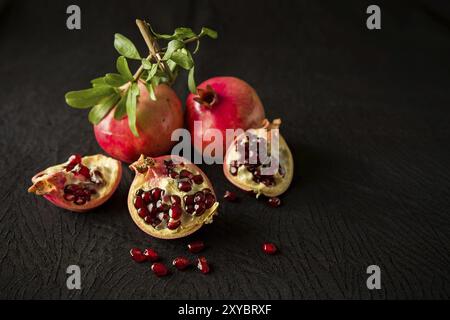 Frutti di melograno e i semi di più di una texture di sfondo nero Foto Stock