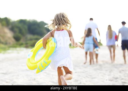 Giovane ragazza bionda in esecuzione sul faggio. La vacanza estiva e il concetto di viaggio Foto Stock