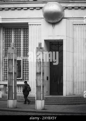 Una foto in bianco e nero di un uomo incorniciato da due baraccopoli di fronte al Kunstforum di Vienna. Foto Stock