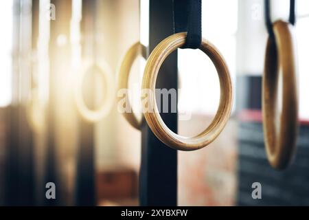 Palestra, fitness e ginnastica anelli per allenamento, salute e braccia forti per la competizione internazionale. Allenamento, attività e primo piano delle attrezzature Foto Stock