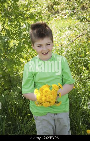 Un ragazzo con un bouquet di tarassaco Foto Stock