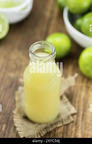 Di succo di lime fresco come dettagliato alta close-up shot su un vintage tavolo in legno (messa a fuoco selettiva) Foto Stock