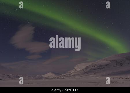 Aurora boreale (Aurora boreale) sulle montagne illuminate dalla luna sul sentiero escursionistico a lunga distanza Kungsleden, Alesjaure, Norrbotten Lapponia, Svezia, 20 marzo Foto Stock