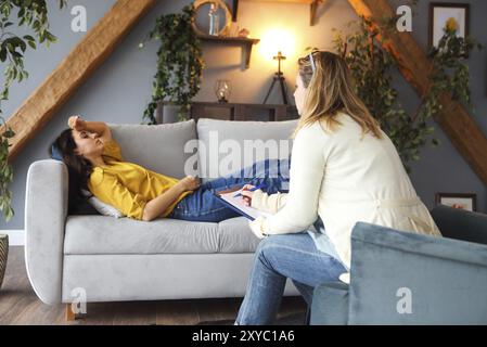 Psicologo avente la sessione con il suo paziente di sesso femminile in her private sala di consultazione Foto Stock