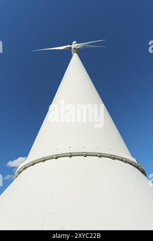 Un'alta turbina eolica bianca contro un cielo blu Foto Stock