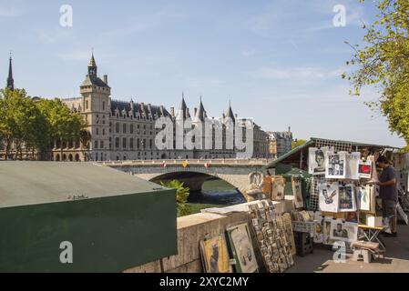 Parigi, Francia. Agosto 2022. Bookstall lungo la Senna con la Conciergerie sullo sfondo Foto Stock