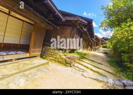 La storica strada di Nakasendo passa attraverso la tradizionale strada sterrata del villaggio rurale di Tsumago in Giappone. Angolo di Rakish Foto Stock