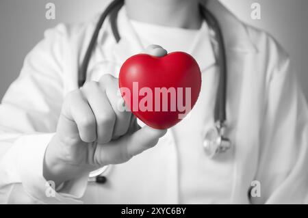 Cuore rosso nella mano di un medico Foto Stock