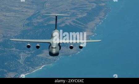 Un C-5M Super Galaxy della U.S. Air Force assegnato alla Travis Air Force base, California, si avvicina per un rifornimento aereo con una colomba KC-10 Extender Foto Stock