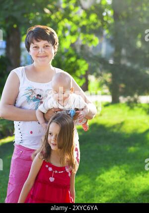 La madre e i suoi bambini all'aperto. Felice la mamma e i suoi bambini giocare nel parco insieme. Outdoor ritratto di famiglia felice Foto Stock