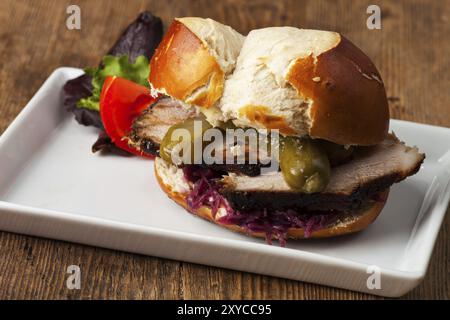 Hamburger bavarese con maiale arrosto in un panino di pretzel Foto Stock