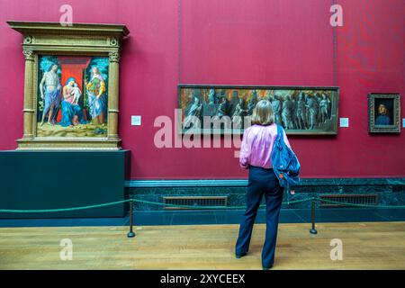 London National Gallery Art Museum veduta interna di una donna elegante che si gode di dipinti e mostre d'arte. All'interno del museo d'arte di Londra in Inghilterra, Regno Unito. Foto Stock