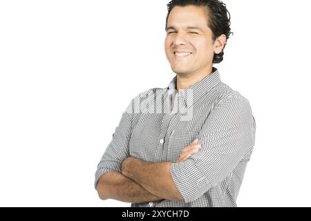 Un bell'aspetto latino-americano che indossa una camicia con bottone giù che ride con le braccia incrociate guardando la fotocamera mostrando facile, caldo, amichevole, pos Foto Stock