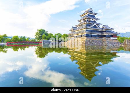 Una luce soffusa della sera sulla tenuta del castello di Matsumoto e sul cielo mentre il riflesso dell'acqua del fossato mostra l'immagine speculare nella prefettura di Nagano, Giappone, Asia Foto Stock