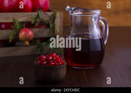 Succo di melograno e frutta su sfondo di legno scuro, messa a fuoco selettiva Foto Stock