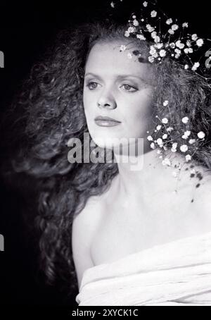 Ritratto in studio di una giovane donna con capelli ricci. Foto Stock