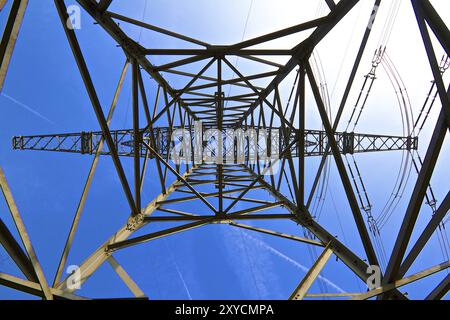 Fotografato al centro del pilone elettrico contro un cielo blu profondo Foto Stock