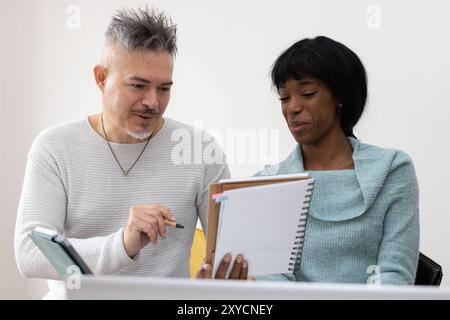 Uomo d'affari e donna d'affari stanno discutendo di un progetto, lavorando insieme in ufficio Foto Stock