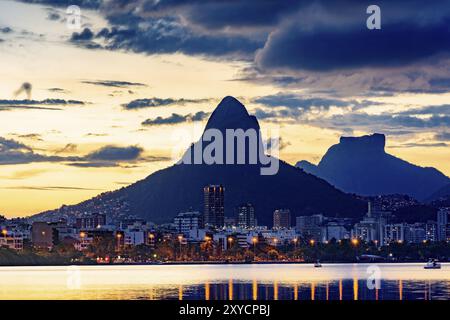 Gli edifici del quartiere di Leblon con i due fratelli hill, Gavea pietra e Rocinha baraccopoli in background durante l'estate tramonto Foto Stock