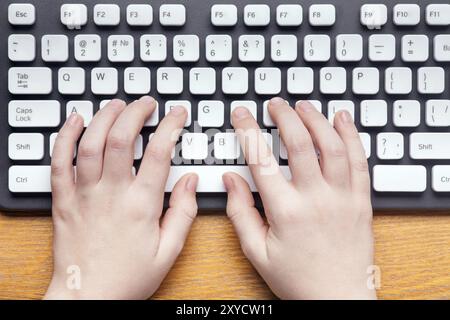 Lavoro al computer. Vista dall'alto delle mani che digitano qualcosa sulla tastiera del computer Foto Stock