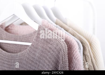 Maglia calda, autunno inverno vestiti appesi a un rack, il concetto di trend, colori pastello Foto Stock