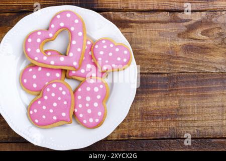 Il giorno di San Valentino a forma di cuore i cookie sul vecchio sfondo di legno.In casa Foto Stock