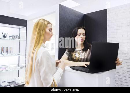 Pretty estetista a parlare con il cliente presso il salone di bellezza Foto Stock